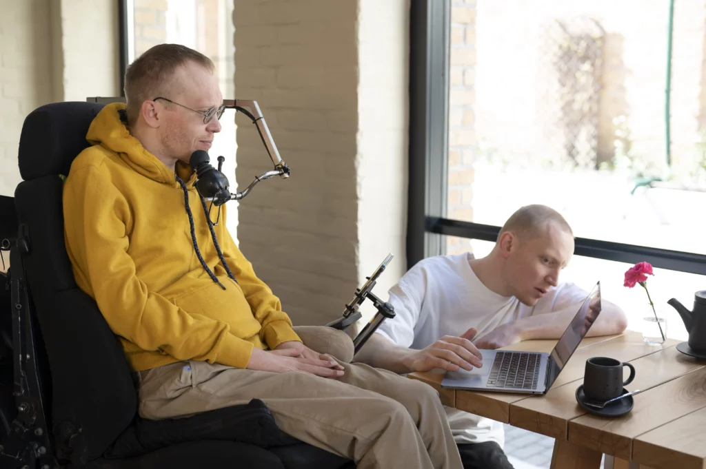 Homme avec un handicap devant un écran d'ordinateur
